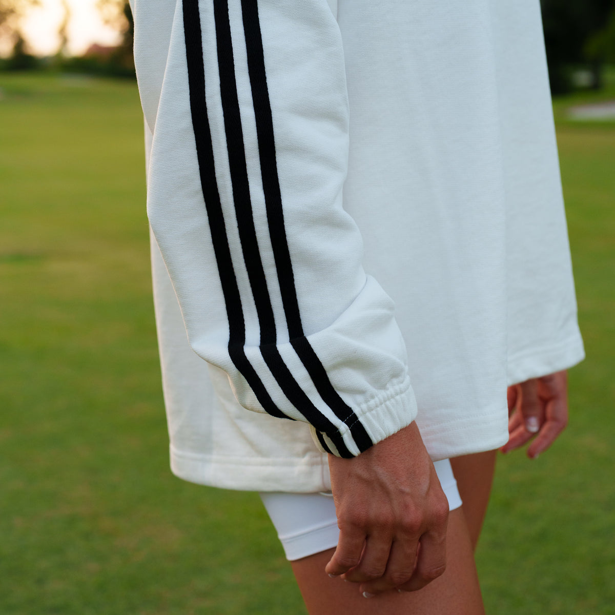 White Motier Lafayette Club De Motier varsity pullover with striped cuffs and collar, featuring embroidered logo detail.