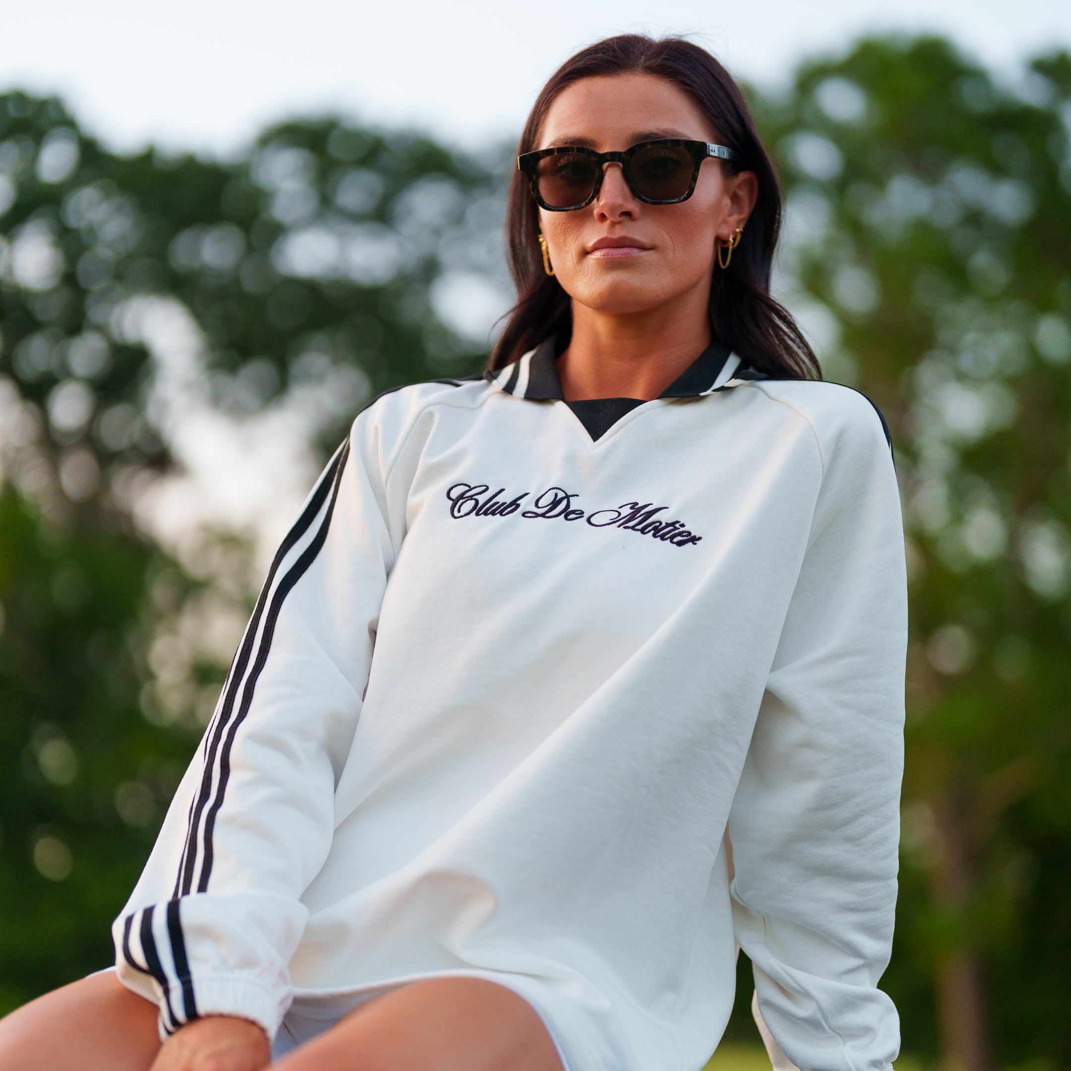 White Club De Motier varsity pullover by Motier Lafayette, featuring a classic athletic design with embroidered logos and striped cuffs.