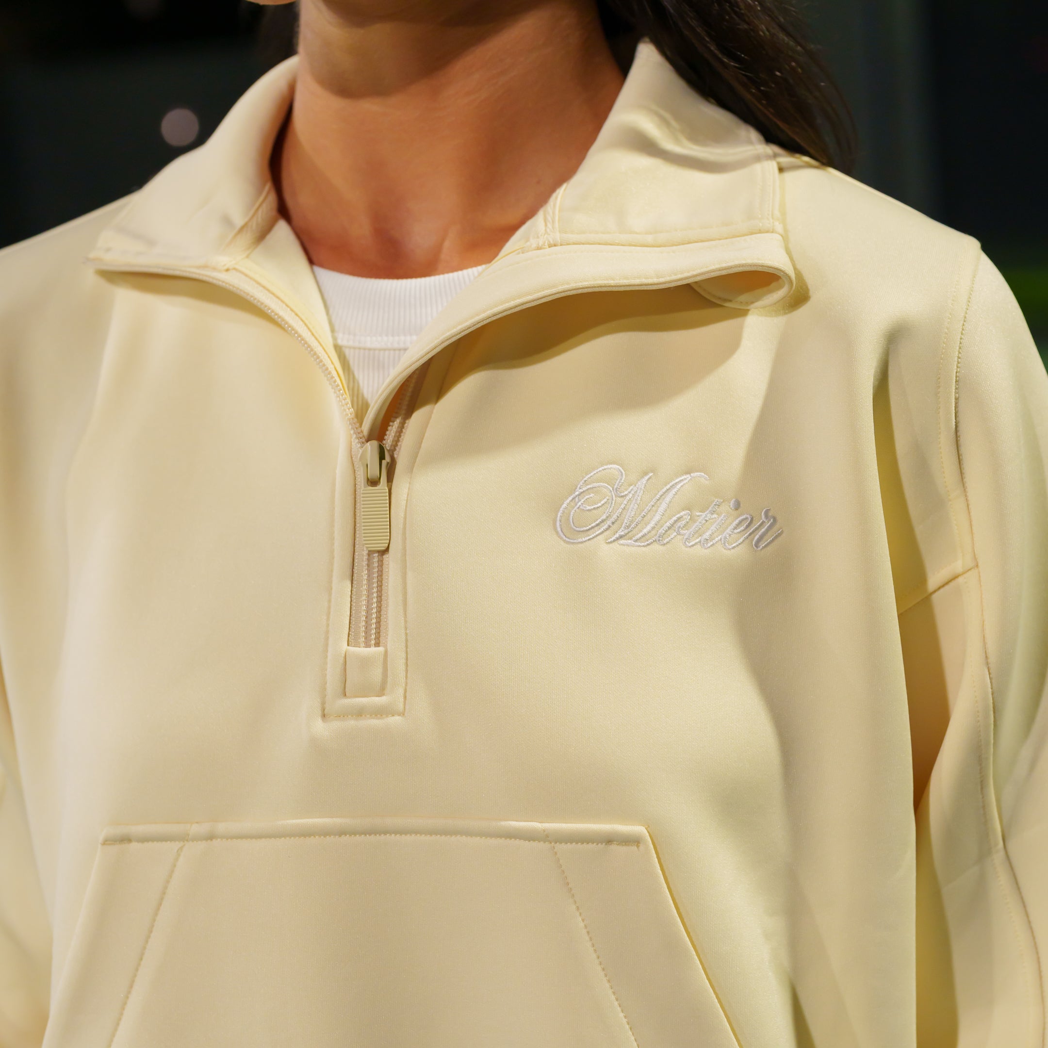 Motier Lafayette Grand Script Scuba Quarter Zip sweater in ivory, featuring a high neckline and stylish branding detail.