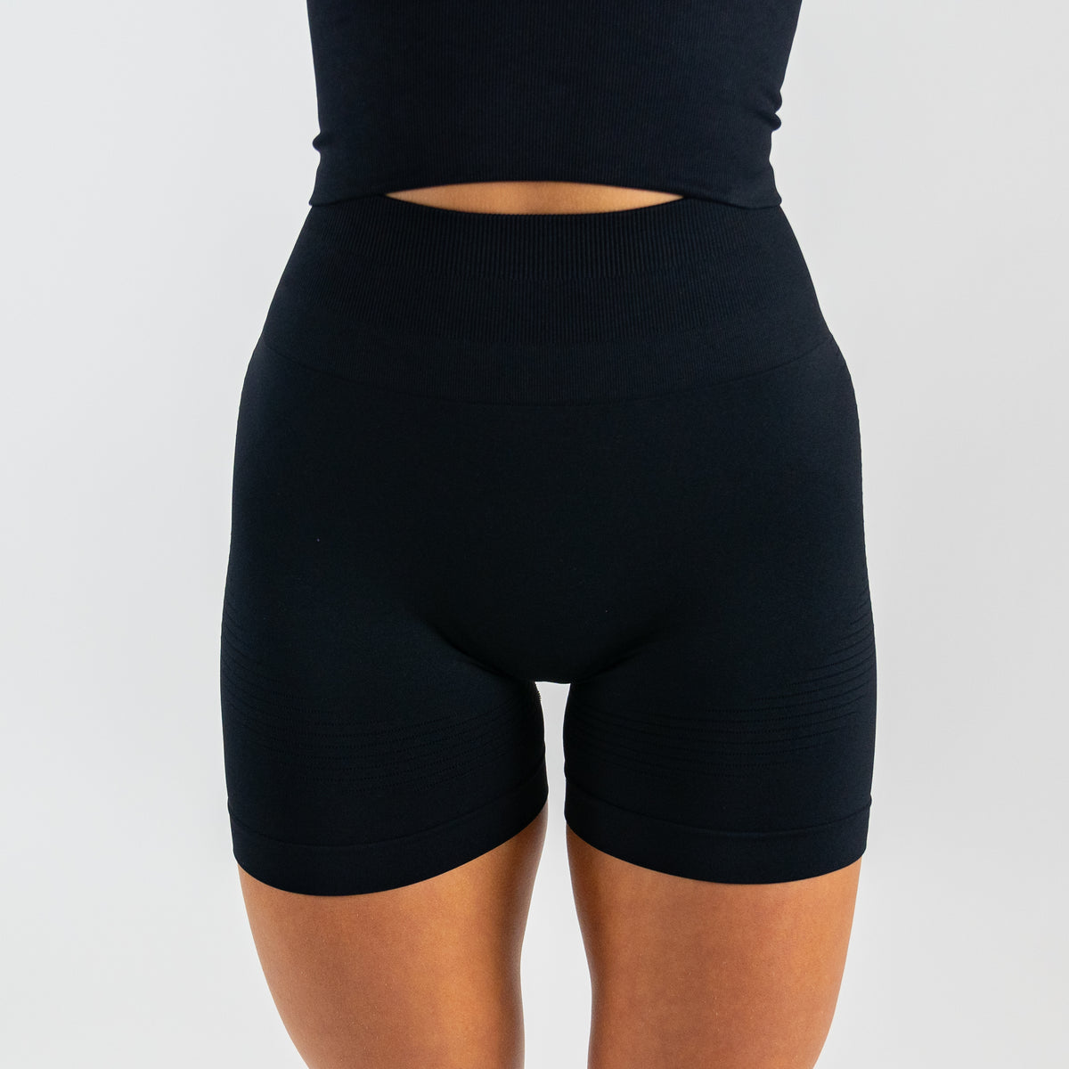 Black Seamless Sculptflex Biker Shorts by Motier Lafayette, close-up of stretchy, form-fitting athletic bottom with smooth seamless design.