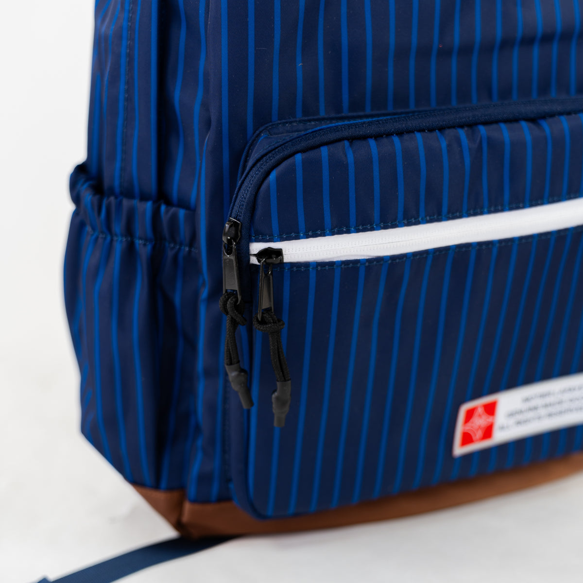 Navy pinstripe backpack from Motier Lafayette's The Legacy II collection, featuring multiple compartments and adjustable straps.