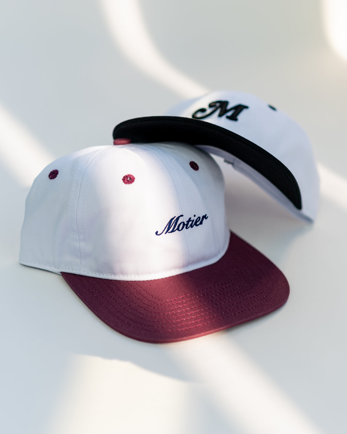Motier Lafayette Two Tone Script Strapback hat in maroon, white, and navy with adjustable strap and embroidered logo.