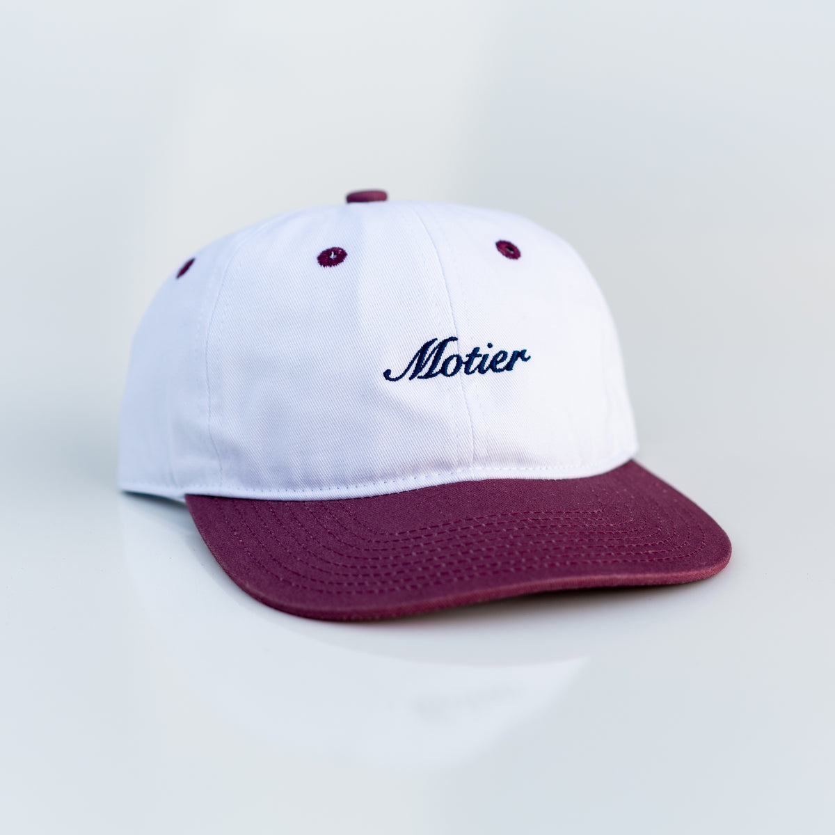 Motier Lafayette Two Tone Script Strapback hat in maroon, white, and navy with adjustable strap and embroidered script logo.