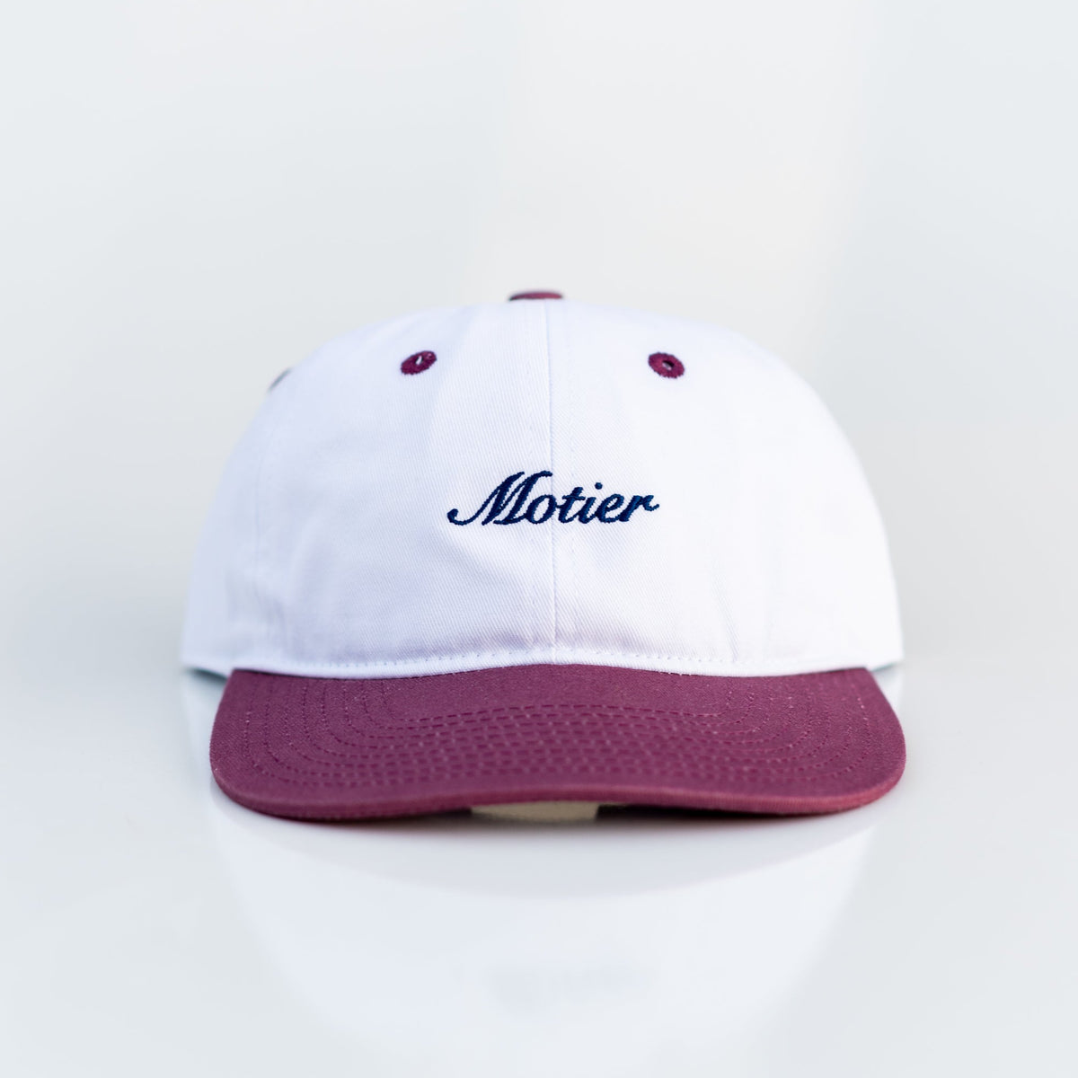 Motier Lafayette Two Tone Script Strapback hat in maroon, white, and navy with adjustable strap and embroidered logo details.