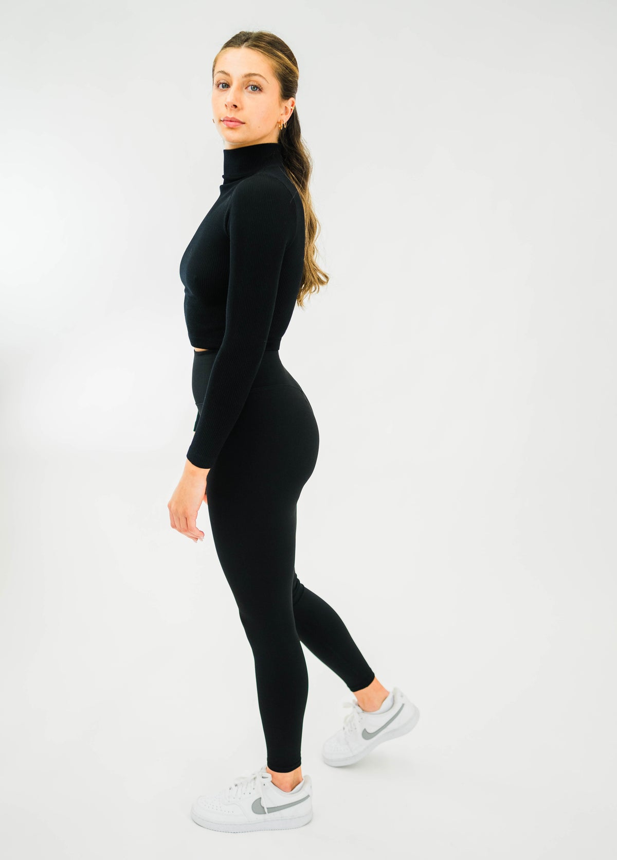 Black women's ribbed long-sleeve mock-neck top by Motier Lafayette, close-up of fitted fabric and stylish neckline.