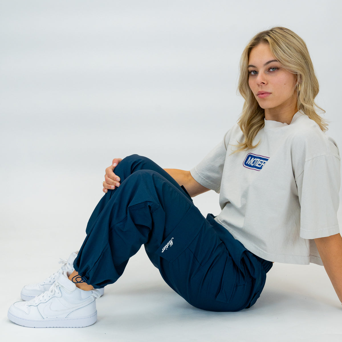 Women's navy nylon track pants by Motier Lafayette, casual athletic pants with a relaxed fit and elastic waistband.