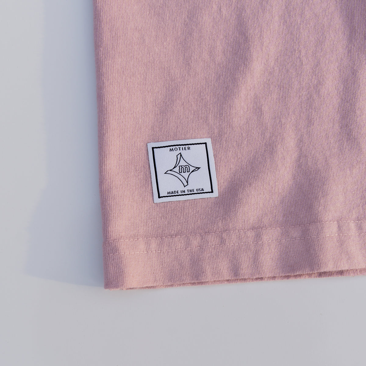Motier Lafayette Royale Crest Embroidery Premium Luxe Tee in Pale Mauve, close-up of embroidered crest and soft fabric texture.