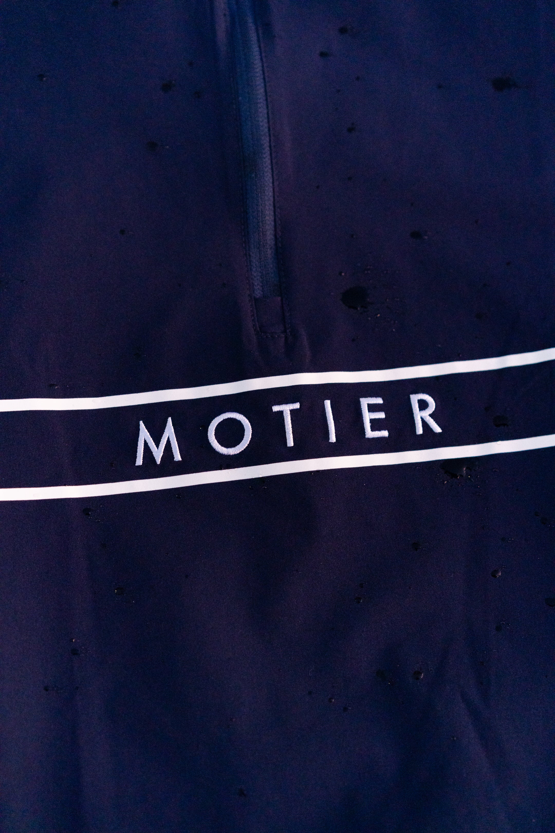 Navy Thomas Élite Pullover by Motier Lafayette, featuring a classic knit design and ribbed cuffs, shown on a hanger.