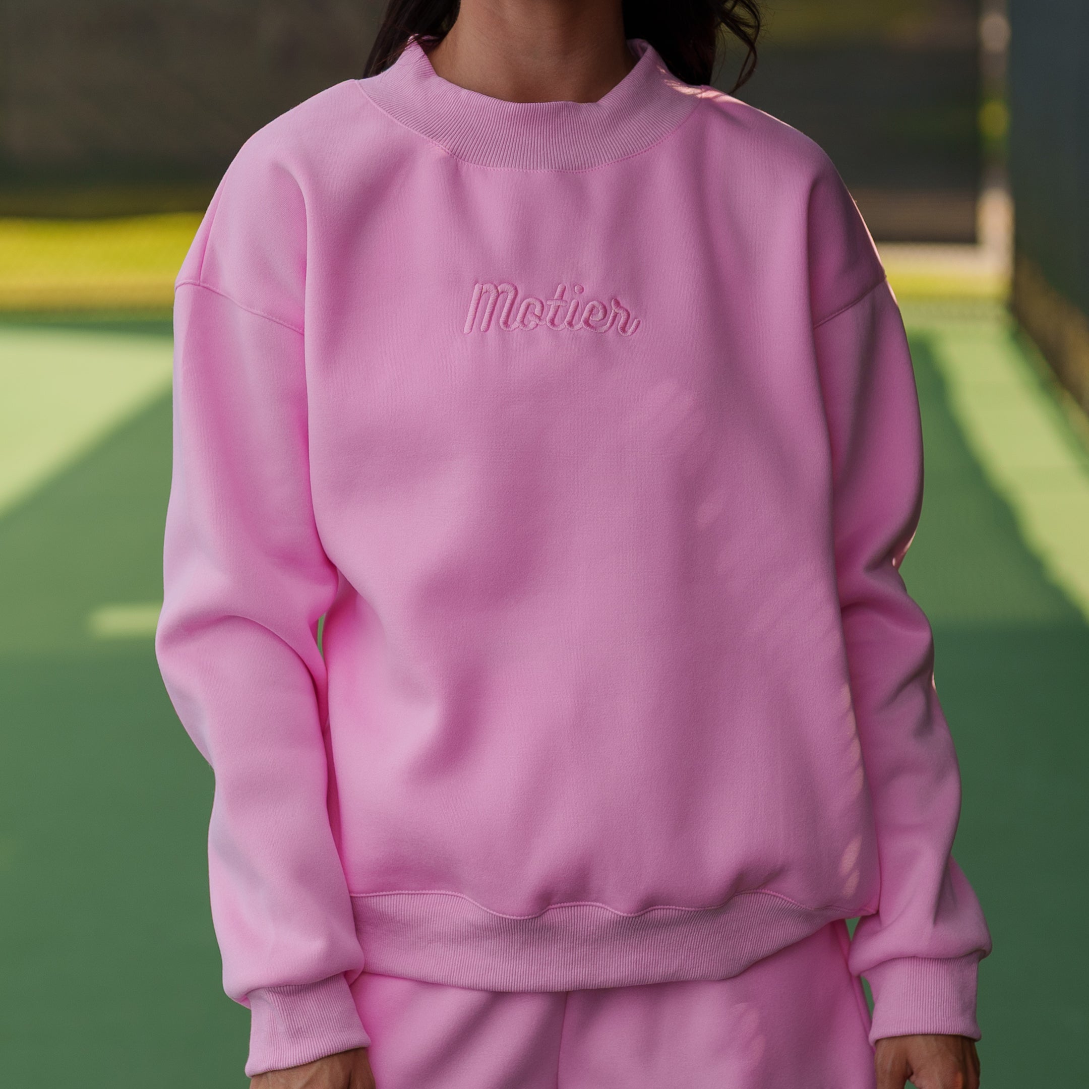 Pink The Pin Script Mock Neck Sweater by motierlafayette, featuring a stylish mock neck and script detail, displayed on a model.